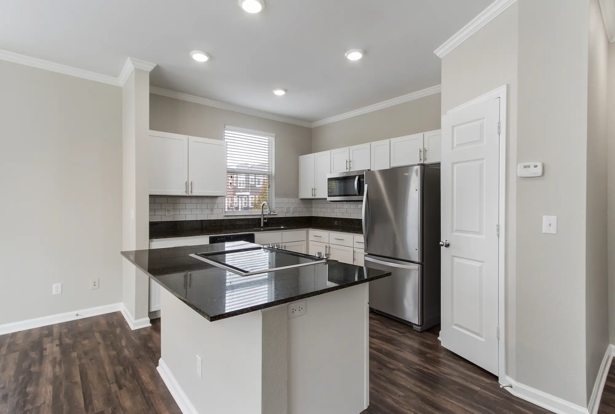 Kitchen with stainless steel appliances, granite counter tops, and tile back splash