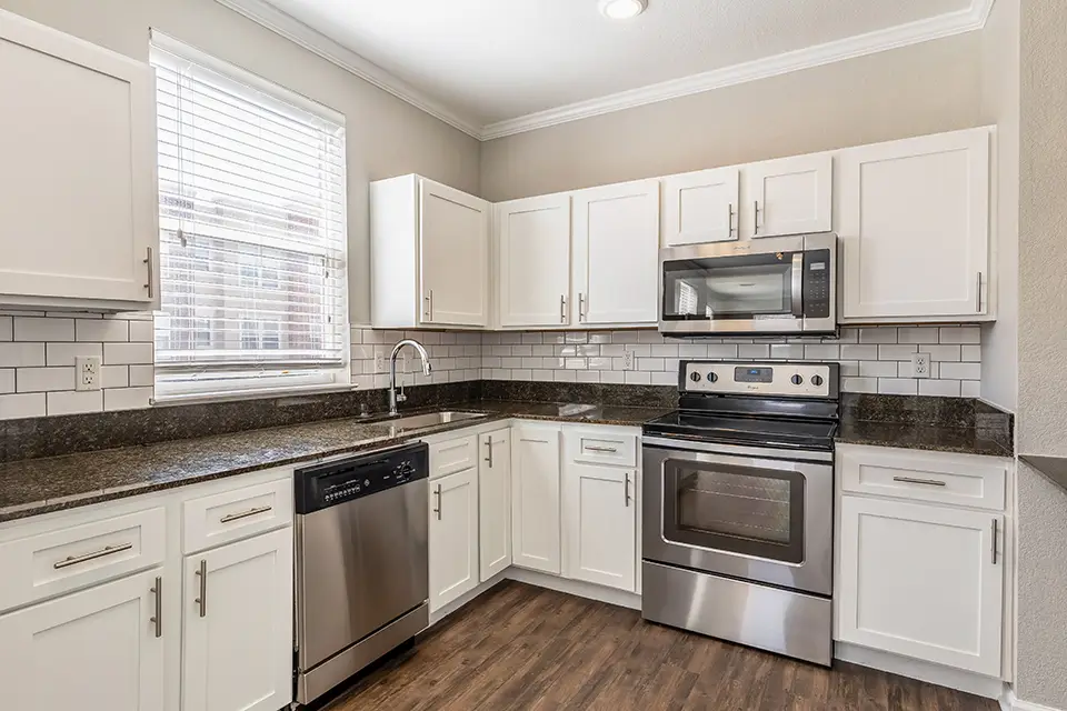 Kitchen with stainless steel appliances, tile backsplash, and granite counter tops